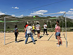 A group of people playing 9 Square in the Air on a sunny day.